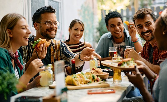 Patient eating with friends after dental implant surgery in Cary