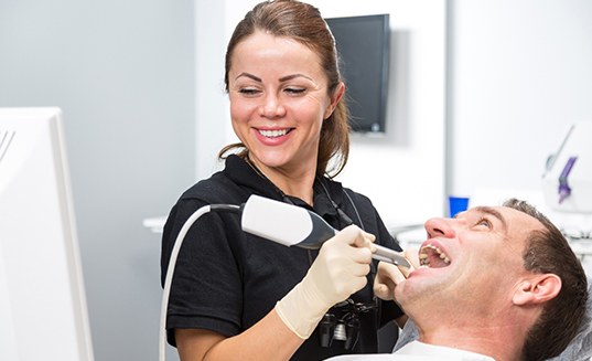 A dental technician taking digital impressions of a patient&rsquo;s tooth
