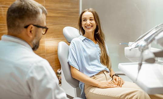  a dentist holding a model of a tooth in one hand and a piggy bank in another